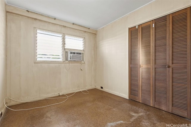 unfurnished bedroom featuring cooling unit and a closet