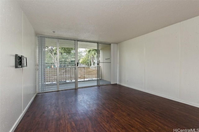 empty room with expansive windows, a textured ceiling, and dark hardwood / wood-style flooring