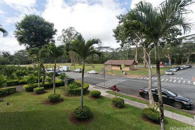 view of parking / parking lot featuring a lawn