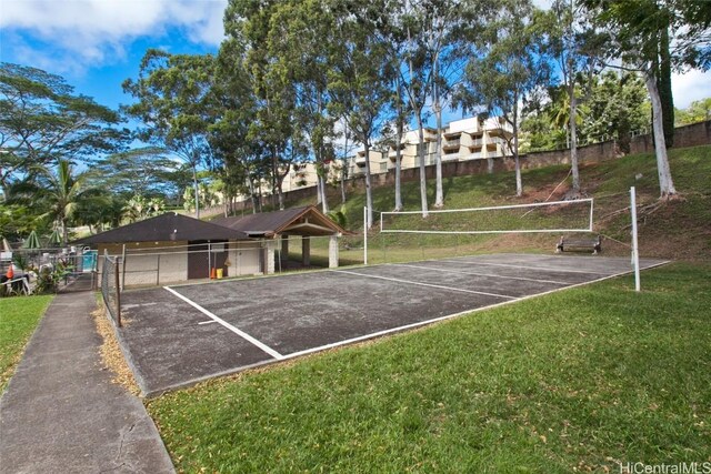 view of property's community featuring a lawn and volleyball court