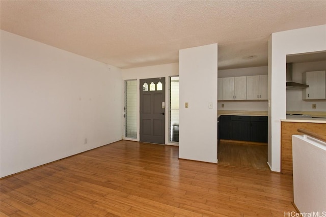 foyer entrance featuring a textured ceiling and light hardwood / wood-style flooring