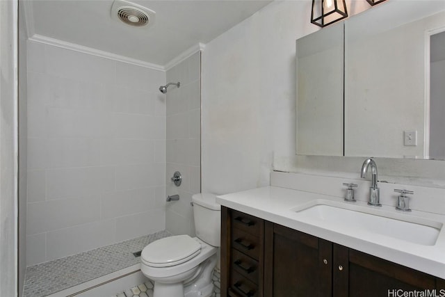 bathroom with vanity, toilet, and tiled shower