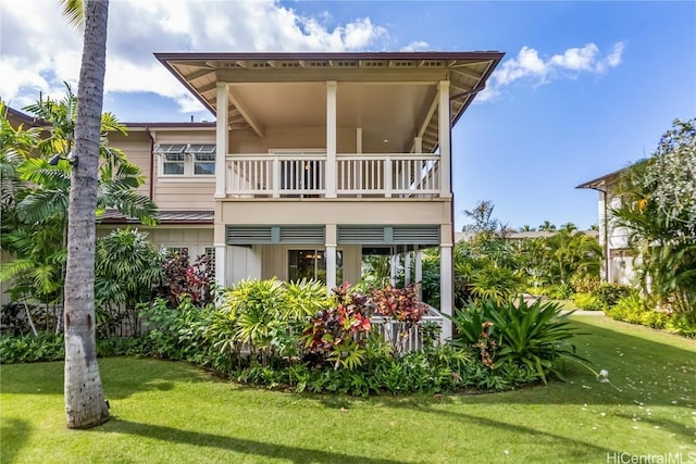 back of house with a lawn and a balcony