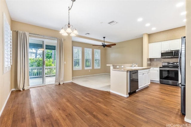 kitchen with white cabinetry, decorative light fixtures, light hardwood / wood-style flooring, appliances with stainless steel finishes, and decorative backsplash