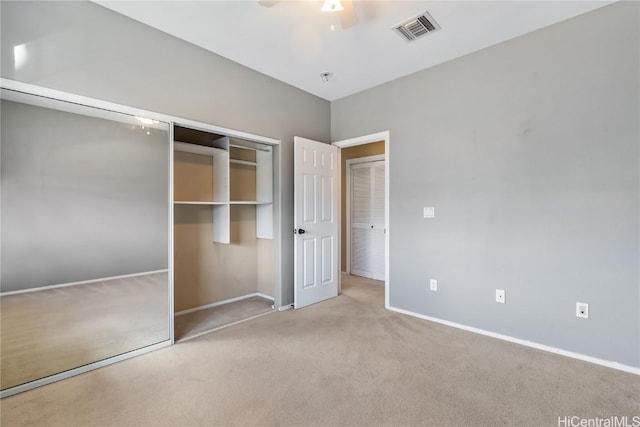 unfurnished bedroom with light carpet, a closet, and ceiling fan