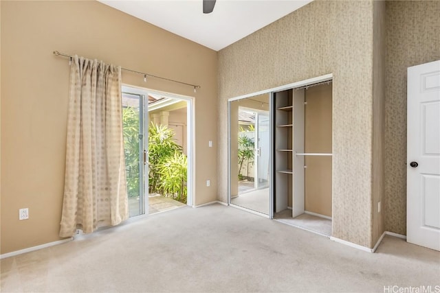 unfurnished bedroom featuring light carpet, access to exterior, and ceiling fan