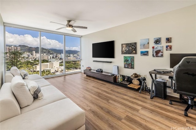 living room featuring expansive windows, wood-type flooring, and ceiling fan