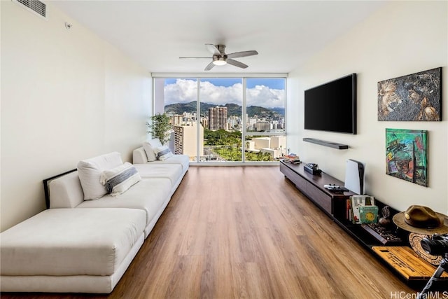 living room featuring floor to ceiling windows, hardwood / wood-style floors, and ceiling fan