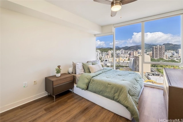 bedroom with dark wood-type flooring, ceiling fan, and expansive windows