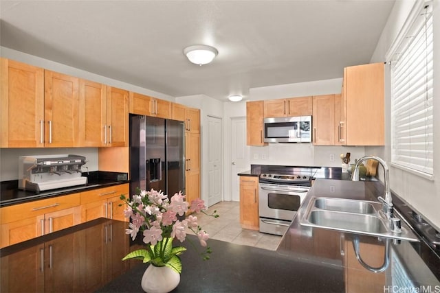 kitchen featuring sink, light tile patterned floors, and stainless steel appliances