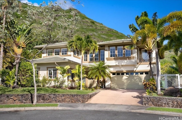 view of front facade with a mountain view, a garage, and a balcony