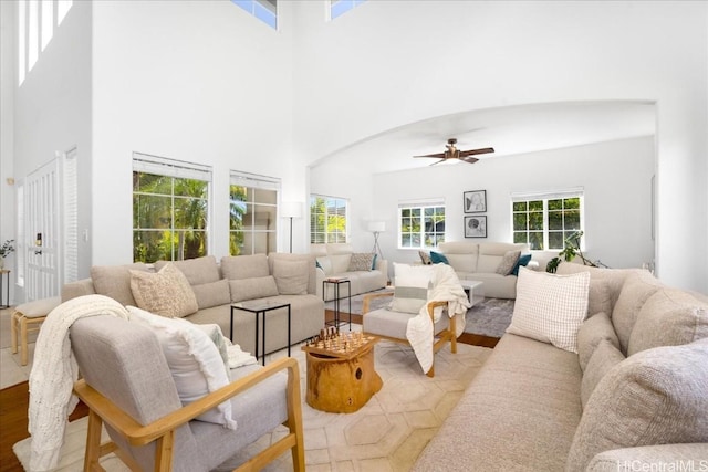 living room featuring a towering ceiling and ceiling fan