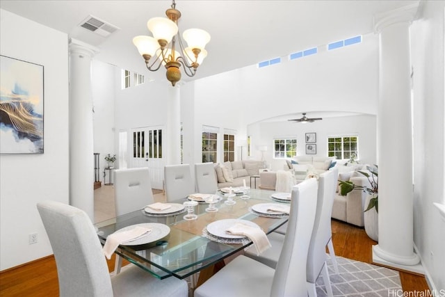 1098 Kuekue St, Honolulu, HI 96825 - dining space featuring decorative columns, a chandelier, a ceiling fan, wood finished floors, and a towering ceiling