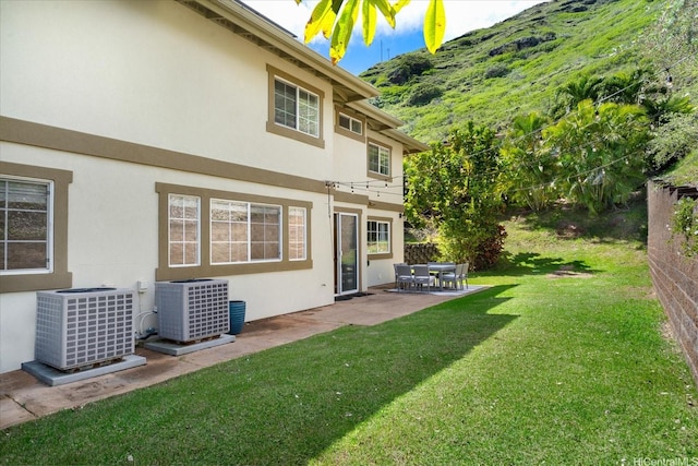 1098 Kuekue St, Honolulu, HI 96825 - back of property with central air condition unit, a patio area, a yard, and stucco siding