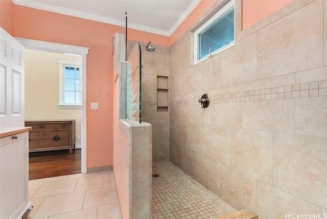 bathroom with crown molding, tile patterned floors, and a tile shower