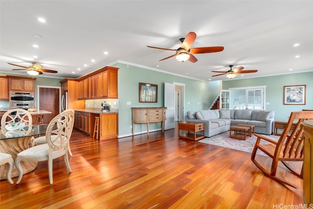 living room featuring ornamental molding and light hardwood / wood-style flooring