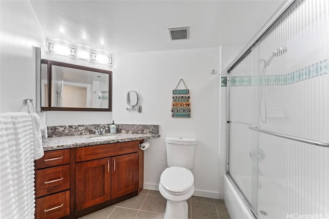 full bathroom featuring bath / shower combo with glass door, tile patterned floors, toilet, and vanity