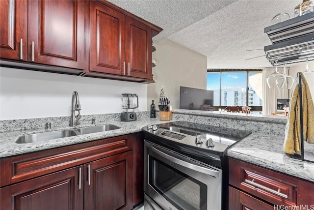 kitchen featuring light stone counters, sink, stainless steel electric range, and a textured ceiling