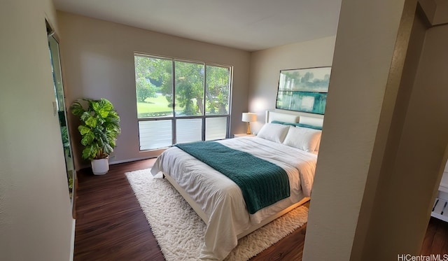 bedroom with access to exterior and dark wood-type flooring