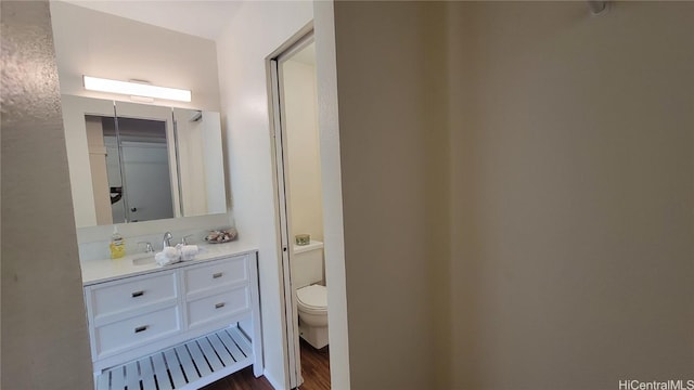 bathroom with vanity, hardwood / wood-style floors, and toilet