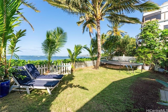 view of yard featuring a water view and a trampoline