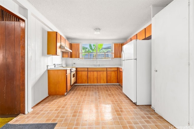 kitchen with a textured ceiling and white appliances