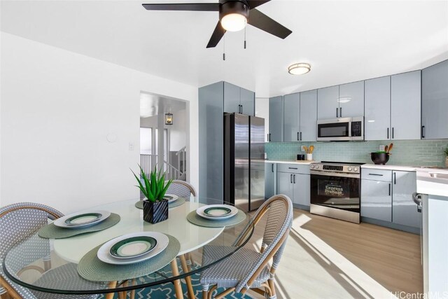 kitchen featuring stainless steel appliances, gray cabinetry, backsplash, and light hardwood / wood-style floors