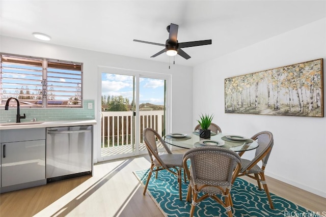 dining space with ceiling fan, light wood-style flooring, and baseboards