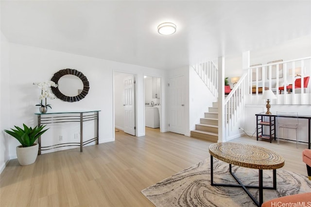 interior space with stairs, wood finished floors, washer / dryer, and baseboards