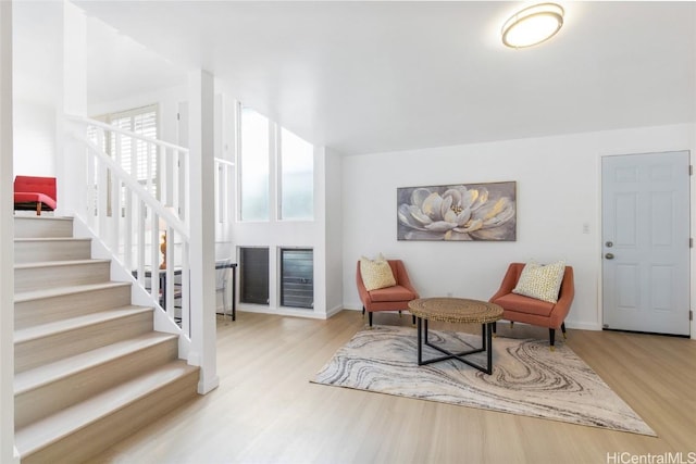 sitting room featuring stairway and light wood finished floors