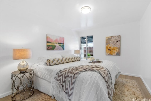 bedroom featuring light wood finished floors and baseboards