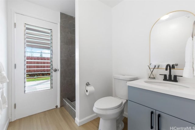 full bath featuring toilet, wood finished floors, a shower stall, and vanity