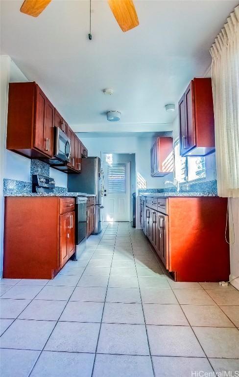 kitchen featuring dark stone countertops, sink, and light tile patterned flooring