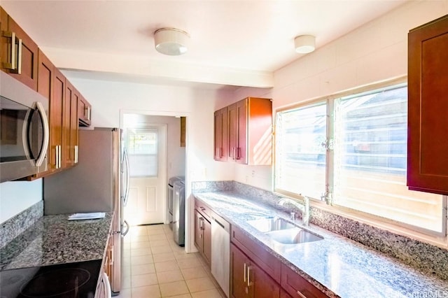 kitchen with light stone countertops, appliances with stainless steel finishes, a wealth of natural light, and separate washer and dryer