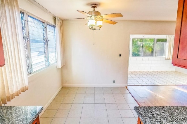 spare room with ceiling fan, a healthy amount of sunlight, and light tile patterned floors