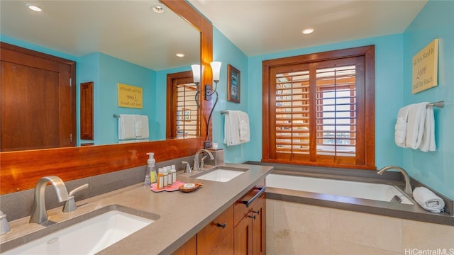 bathroom with tiled tub and vanity