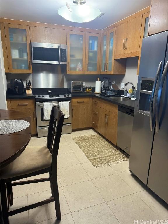 kitchen with stainless steel appliances, sink, and light tile patterned floors