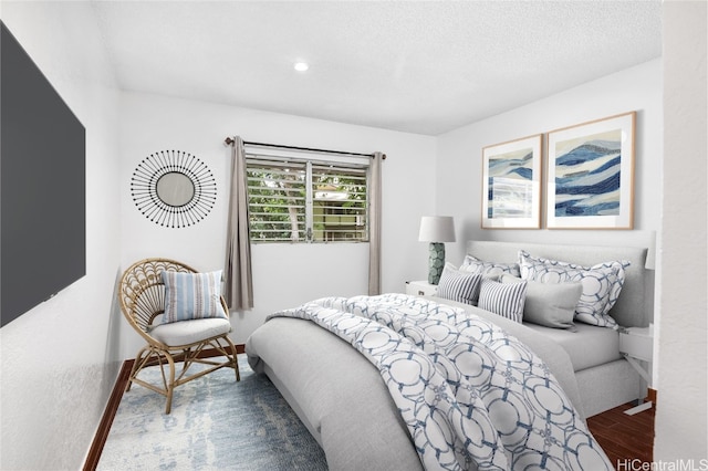 bedroom featuring dark hardwood / wood-style floors and a textured ceiling