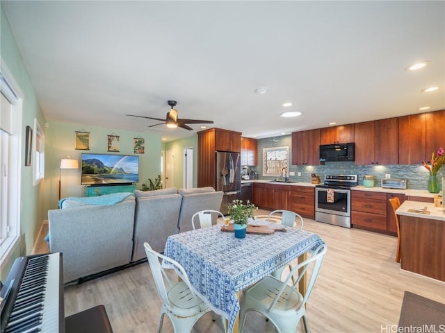 dining area with ceiling fan, sink, and light hardwood / wood-style floors