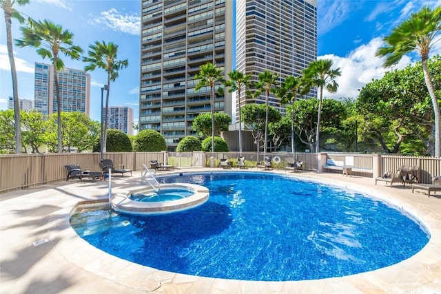 view of swimming pool with a patio area and a hot tub