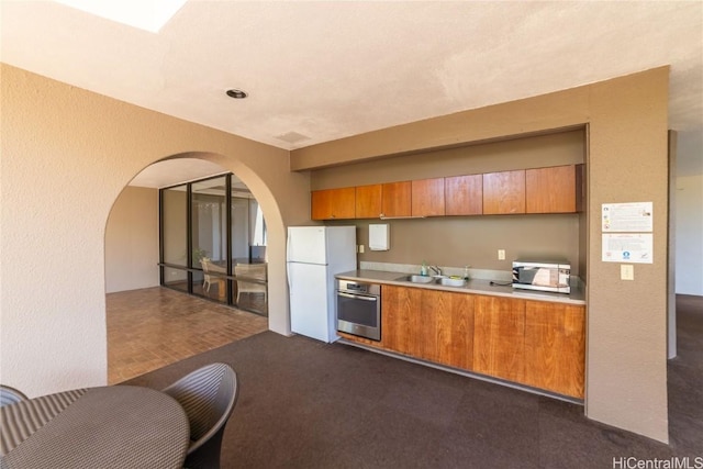 kitchen featuring sink, dark carpet, and stainless steel appliances