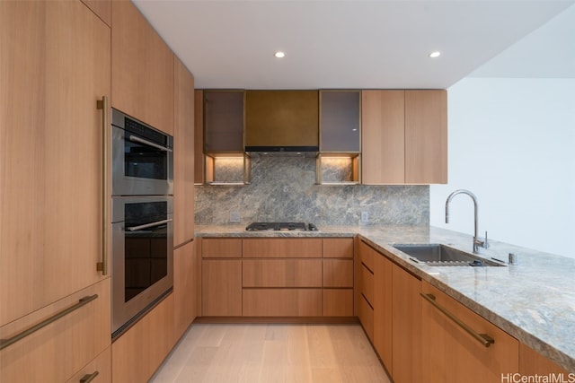 kitchen featuring light brown cabinetry, tasteful backsplash, sink, stainless steel appliances, and light stone countertops