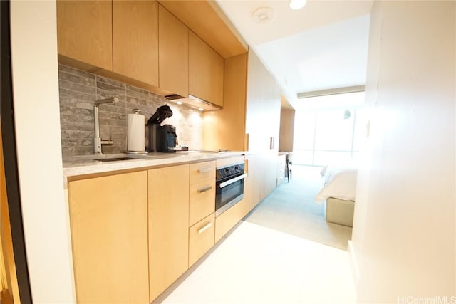 kitchen featuring light brown cabinetry, sink, black electric stovetop, oven, and decorative backsplash