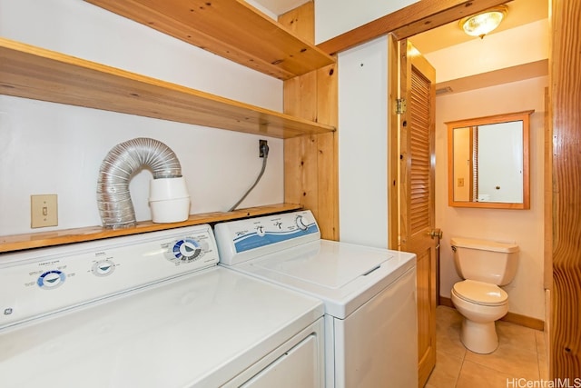 laundry area with washer and dryer and light tile patterned floors