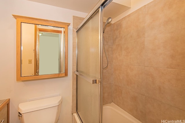 full bathroom featuring vanity, shower / bath combination with glass door, and toilet