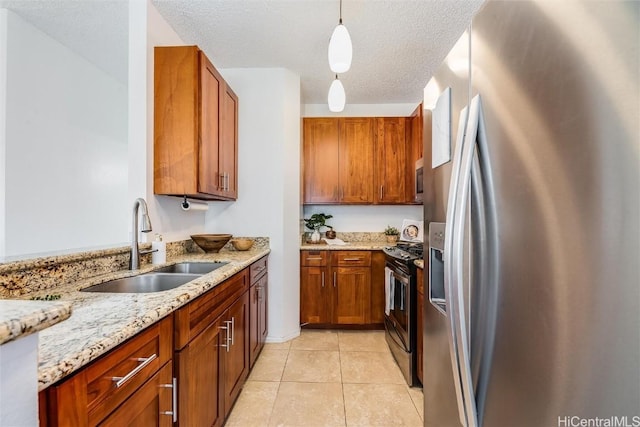 kitchen featuring sink, hanging light fixtures, light tile patterned floors, appliances with stainless steel finishes, and light stone countertops