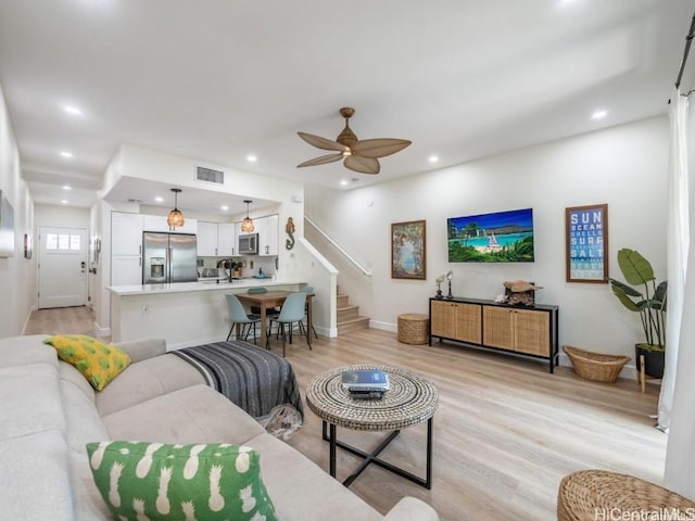 living room with light hardwood / wood-style floors and ceiling fan