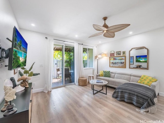 living room featuring ceiling fan and light hardwood / wood-style floors