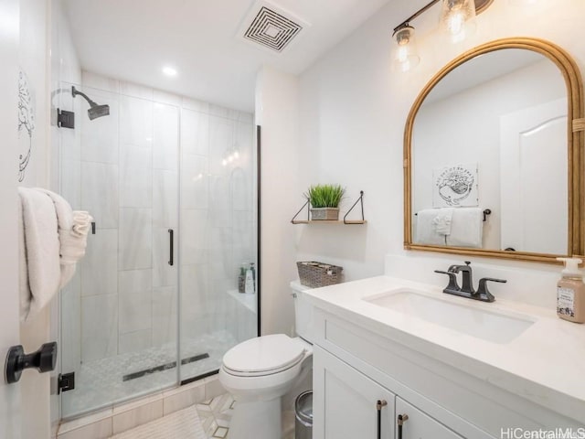 bathroom featuring vanity, toilet, and a shower with door