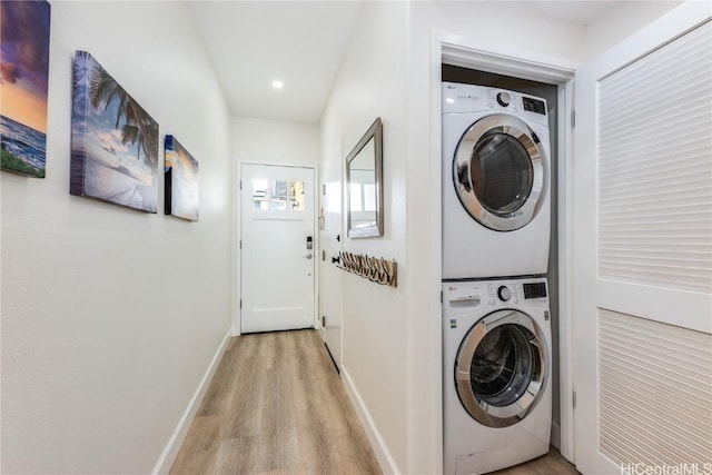 washroom featuring stacked washer and clothes dryer and light hardwood / wood-style floors